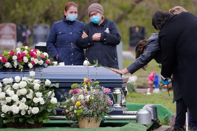 Aracely Iraheta touches the casket of her husband, Jose Agustin Iraheta, who died from the coronavirus disease (COVID-19), in Malden, Massachusetts, U.S., May 12, 2020. (Photo by Brian Snyder/Reuters)