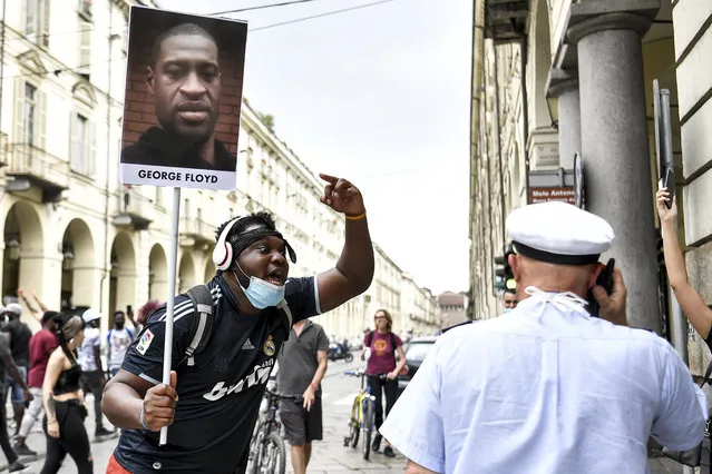 A man holding a picture of George Floyd attends a flash mob calling for justice for George Floyd, who died May 25 after being restrained by police in Minneapolis, USA, in Turin, Italy, Saturday, June 6, 2020. Several hundred people have protested peacefully in Turin, Italy, to denounce the police killing of George Floyd and show solidarity with anti-racism protests in the U.S. and elsewhere. (Photo by Fabio Ferrari/LaPresse via AP Photo)
