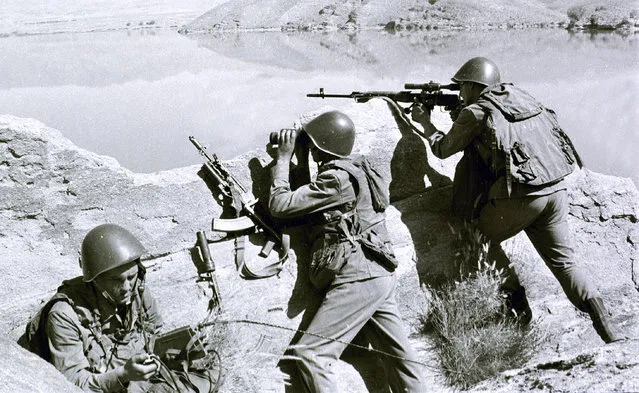 In this late April 1988, file photo, Soviet soldiers observe the highlands, while fighting Islamic guerrillas at an undisclosed location in Afghanistan. Moscow and Washington are intertwined in a complex and bloody history in Afghanistan, with both suffering thousands of dead and wounded in conflicts lasting for years. Now both superpowers are linked again over Afghanistan, with intelligence reports indicating Russia secretly offered bounties to the Taliban to kill American troops there. But analysts suggest that the two adversaries actually have more in common, especially when it comes to what they want to see in a postwar Afghanistan: a stable country that does not serve as a base for extremists to export terrorism. Both countries also are aligned in their opposition to militants from the Islamic State group. (Photo by Alexander Sekretarev/AP Photo/File)