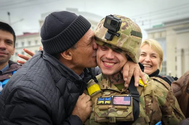 A Kherson resident kisses a Ukrainian soldier in central Kherson, Ukraine, Sunday, November 13, 2022. The Russian retreat from Kherson marked a triumphant milestone in Ukraine's pushback against Moscow's invasion almost nine months ago. (Photo by Efrem Lukatsky/AP Photo)