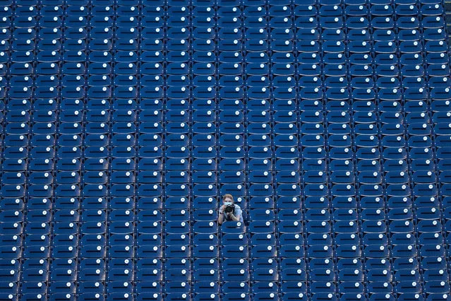 A sports photographer sits in empty spectator seats as the Toronto Blue Jays play the Washington Nationals at Nationals Park on July 29, 2020 in Washington, DC. MLB has resumed its delayed season without fans due to the COVID-19 pandemic. (Photo by Patrick Smith/Getty Images)