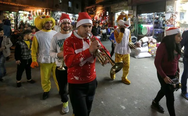Syrian youths dressed in Christmas outfits and other costumes play trumpets and other musical instruments while roaming the streets of the capital Damascus, as they celebrate Christmas eve on December 24, 2017. (Photo by Louai Beshara/AFP Photo)