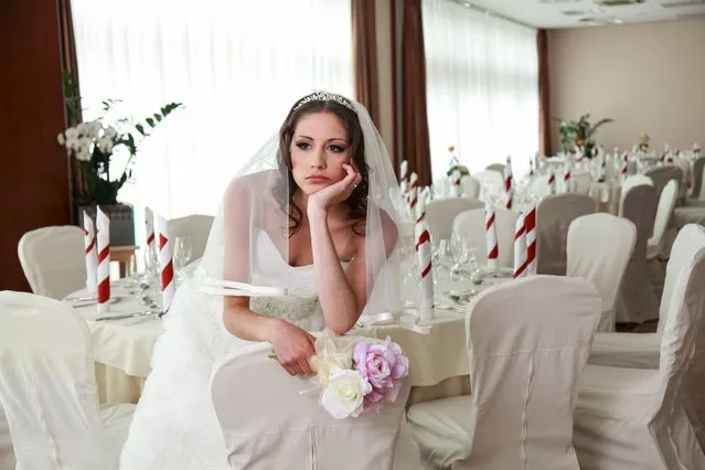 Bride sitting in a ceremony waiting restaurant. Sitting sad with head and flowers in her hands. (Photo by tomazl/Getty Images)