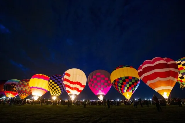 Hot air balloons are lit up by flame as they prepare to take off on the first day of the 2015 Albuquerque International Balloon Fiesta in Albuquerque, New Mexico, October 3, 2015. (Photo by Lucas Jackson/Reuters)