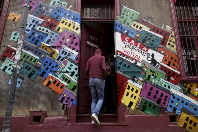 A man enters a house painted with graffiti on a street in Valparaiso, Chile, June 26, 2015. (Photo by Ueslei Marcelino/Reuters)