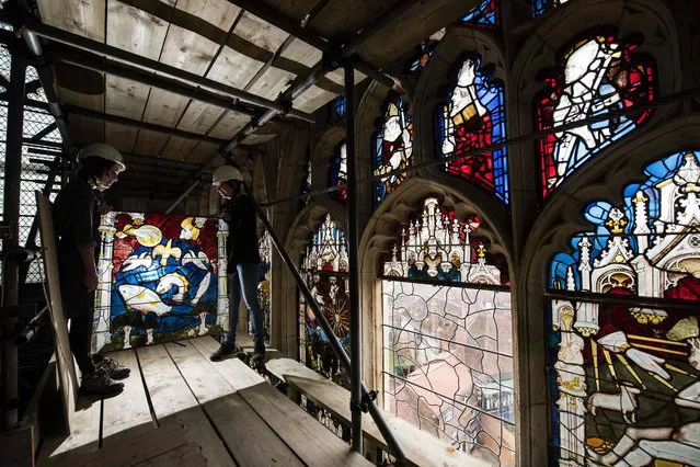 Conservators Zoe Harrigan (R) and Anna Milsom replace the final stained glass panel in York Minster' s 600 year- old Great East Window, following a 10- year conservation and restoration project, in York, northern England on January 2, 2018. All 311 panels of the window, which is the country' s largest single expanse of medieval stained glass, were removed and restored by York Glaziers Trust - a task which took 92,400 hours and cost 11.5 million pounds. The window was created between 1405 and 1408 by the master glazier John Thornton, who was paid 56 pounds by the Chapter of York, and it depicts the beginning and end of all things from the book of Genesis to the book of Revelation. (Photo by Oli Scarff/AFP Photo)