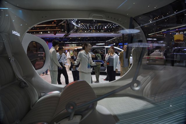 A worker introduces GOVY Air Car from GAC Group displayed at the Shanghai auto show on Thursday, April 24, 2025. (Photo by Ng Han Guan/AP Photo)