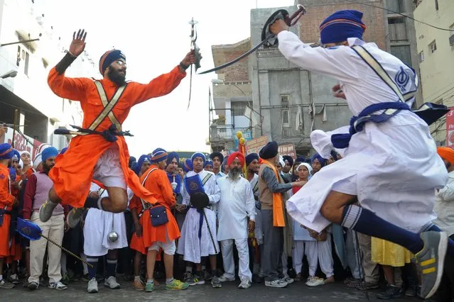 Young Sikhs demonstrate their Gatka martial arts skills during a procession from Sri Akal Takhat to the Golden Temple in Amritsar on November 5, 2014 on the eve of the 545th birth anniversary of Sri Guru Nanak Dev. Guru Nanak was the founder of the religion of Sikhism and the first of ten Sikh Gurus. (Photo by Narinder Nanu/AFP Photo)