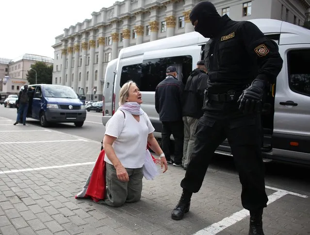 A woman kneels as she talks to a law enforcement officer during a protest of students against presidential election results in Minsk, Belarus on September 1, 2020. (Photo by Tut.By via Reuters)