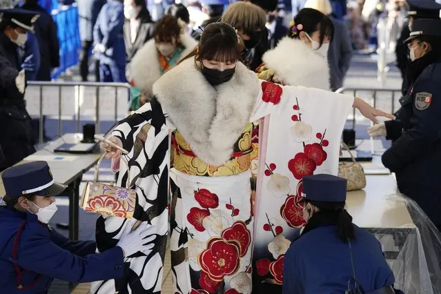 A kimono-clad woman celebrating turning 20 years old, goes through a security check to participate in an official ceremony, used to be called a Coming-of-Age ceremony, Monday, January 9, 2023, in Yokohama near Tokyo. Held annually on the second Monday of January, local municipal celebrate for Japan's young adults. Japan lowered the age of adulthood from twenty years old to 18 years old in 2022. (Photo by Eugene Hoshiko/AP Photo)