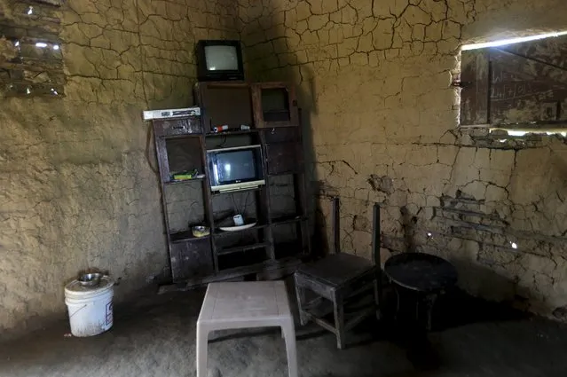 A shelf containing electronics items, including two televisions, is seen inside a mud house in Ikarama village on the outskirts of the Bayelsa state capital, Yenagoa, in Nigeria's delta region October 8, 2015. (Photo by Akintunde Akinleye/Reuters)