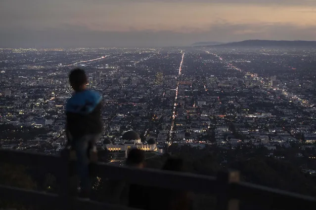 A boy takes in the view of the Los Angeles skyline from the Griffith Park Observatory Trails Peak in Los Angeles, Monday, Nov. 14, 2022. (AP Photo/Jae C. Hong)