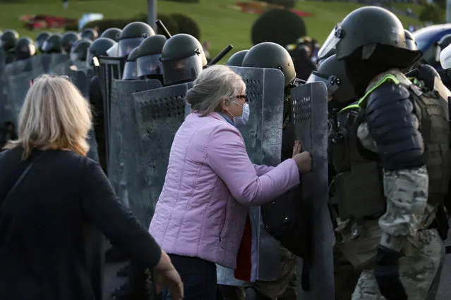 A woman argues with riot police during an opposition rally to protest the presidential inauguration in Minsk, Belarus, Wednesday, September 23, 2020. (Photo by AP Photo/Stringer)