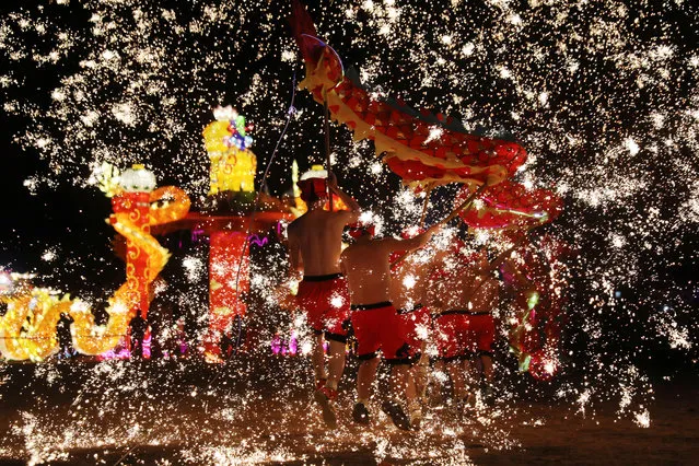Folk artists perform a fire dragon dance under a shower of sparks from molten iron, ahead of the Chinese Lunar New Year, in Shangqiu, Henan province, China February 14, 2018. (Photo by Reuters/China Stringer Network)