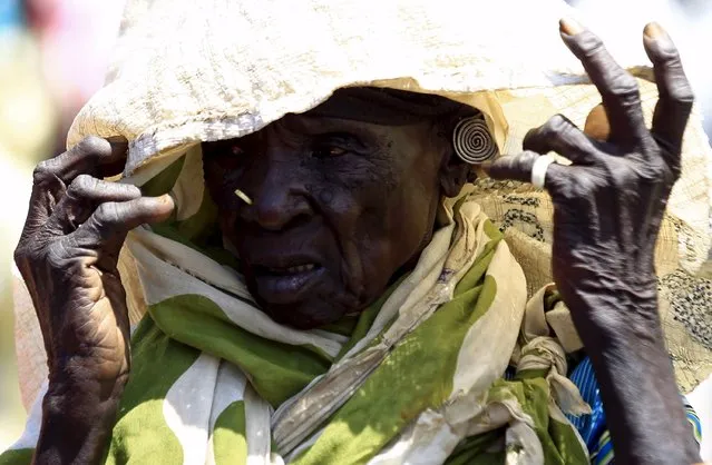 A displaced woman waits to receive food provided by the United Nations' World Food Programme (WFP) during a visit by a European Union delegation, at an IDP camp in Azaza, east of Ad Damazin, capital of Blue Nile state, October 21, 2015. (Photo by Mohamed Nureldin Abdallah/Reuters)