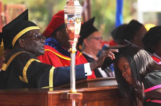 Zimbabwean President Robert Mugabe, left, places a cap on a student at the University of Zimbabwe, during graduation ceremony in Harare, Thursday, September 29, 2016. (Photo by Tsvangirayi Mukwazhi/AP Photo)