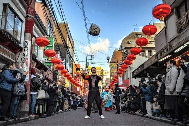 A man performs during a Lunar New Year parade, held for the first time following a three-year hiatus due to the coronavirus pandemic, in the Chinatown area of Yokohama on February 4, 2023. (Photo by Philip Fong/AFP Photo)