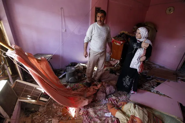 Iraqis examine damage inflicted on their house by a car bomb attack in AL-Mashtal district in Baghdad March 19, 2013. Car bombs and a suicide blast hit Shi'ite districts of Baghdad and south of Iraq's capital on Tuesday, killing at least 50 people on the 10th anniversary of the invasion that ousted Saddam Hussein. (Photo by Mohammed Ameen/Reuters)