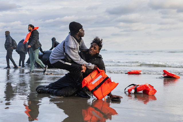 A Sudanese migrant react after leaving a smuggler's boat which was punctured with a knife by French police officers to prevent migrants from embarking in an attempt to cross the English Channelon the beach of Gravelines, near Dunkirk, northern France on April 26, 2024. Five migrants, including a seven-year-old girl, died on April 23, 2024, trying to cross the Channel from France to Britain, local authorities said, just hours after Britain passed a controversial bill to deport asylum seekers to Rwanda. (Photo by Sameer Al-Doumy/AFP Photo)