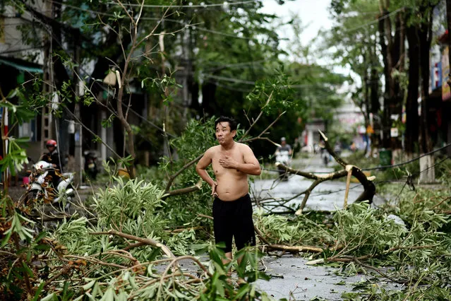 A man reacts while standing amidst uprooted trees in central Vietnam's Quang Ngai province on October 28, 2020, in the aftermath of Typhoon Molave. (Photo by Manan Vatsyayana/AFP Photo)