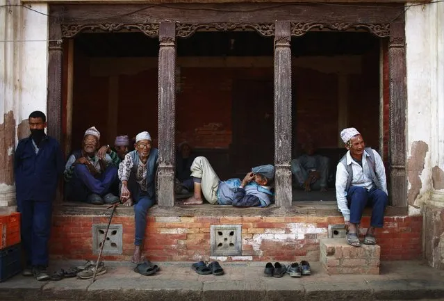 Men pass their time sitting along a street in Bhaktapur, Nepal, on April 4, 2013. (Photo by Navesh Chitrakar/Reuters)