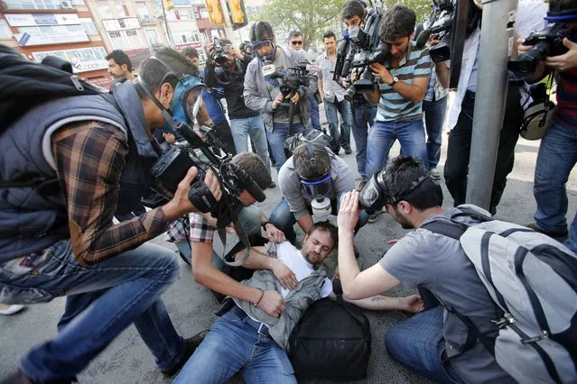 An injured journalist is filmed and helped by his colleagues during clashes between riot police and May Day protesters in central Istanbul May 1, 2013. Turkish riot police clashed with thousands of May Day protesters in Istanbul on Wednesday, firing water cannon and tear gas at crowds that tried to break through barricades to reach the city's main square, witnesses said. The incidents followed the pattern of recent years, when May Day demonstrations in Turkey's largest city have often been marked by clashes between police and protesters. (Photo by Murad Sezer/Reuters)