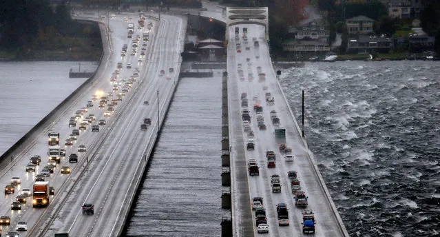 Eastbound traffic lanes, right, on Interstate 90 are dampened by wind-driven waves from the south as the floating bridge calms Lake Washington to the north, left, Tuesday, November 17, 2015, in Seattle. Rain and high winds snarled the morning commute in the Puget Sound area and the Inland Northwest braced for severe weather that could include wind gusts to 70 mph. (Photo by Elaine Thompson/AP Photo)