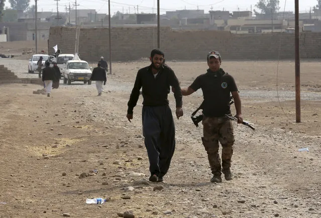 A member of Iraq's elite counterterrorism forces, right, arrests a suspect of Islamic State in the village of Tob Zawa, about 9 kilometers (5½ miles) from Mosul, Iraq, Tuesday, October 25, 2016. (Photo by Khalid Mohammed/AP Photo)