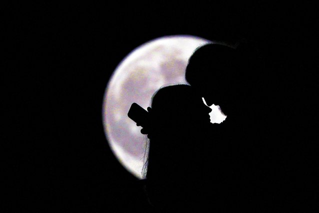 A couple's silhouette as a supermoon, known as the “Hunter's Moon”, rises over Tirana, Albania, on November 5, 2025. (Photo by Florion Goga/Reuters)