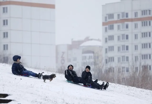 Boys play on a snowy slope after the first snowfall in Minsk, Belarus, November 29, 2015. (Photo by Vasily Fedosenko/Reuters)