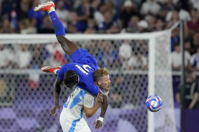 France's Castello Lukeba jumps for the ball with Argentina's Luciano Gondou during a quarter final soccer match between France and Argentina, at Bordeaux Stadium, during the 2024 Summer Olympics, Friday, August 2, 2024, in Bordeaux, France. (Photo by Moises Castillo/AP Photo)