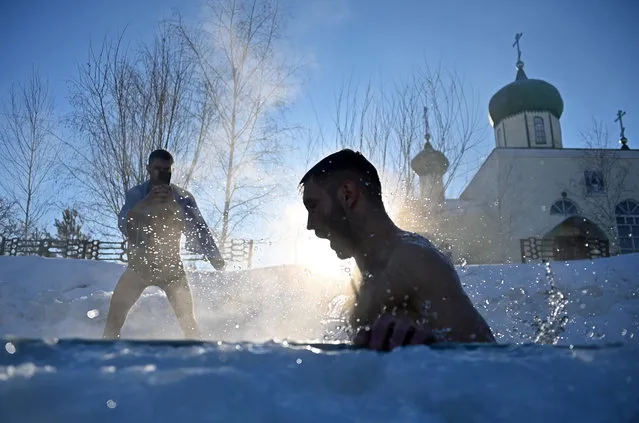 A man takes a dip during celebrations of the Orthodox Christian feast of Epiphany in the settlement of Moskalenki in Omsk Region, Russia on January 19, 2021. (Photo by Alexey Malgavko/Reuters)