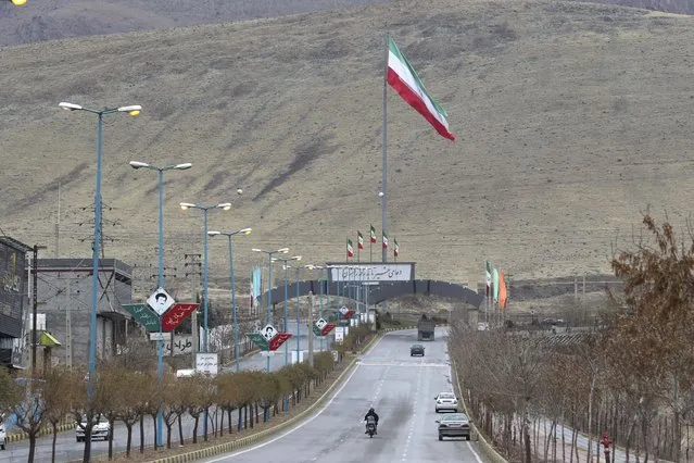 Iran's flag waves at the entrance of Absard,  the town where Mohsen Fakhrizadeh, an Iranian scientist linked to the country's nuclear program was killed by unknown assailants last month, east of the capital, Tehran, Iran, Wednesday, December 16, 2020. Iran's supreme leader and the country's president both warned America on Wednesday that the departure of President Donald Trump does not immediately mean better relations between the two nations. (Photo by Vahid Salemi/AP Photo)