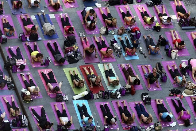 Yoga enthusiast mark the longest day of the year with five free “Mind Over Madness” yoga classes in New York's Times Square, on June 21, 2013. (Photo by Mary Altaffer/Associated Press)