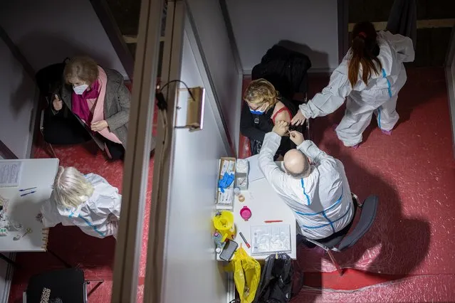 A woman receives a dose of the Chinese Sinopharm vaccine as the country begins mass vaccination against the coronavirus disease (COVID-19), in Belgrade, Serbia, February 2, 2021. (Photo by Marko Djurica/Reuters)