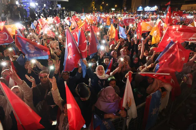 Supporters of Turkish President Tayyip Erdogan wave flags outside the AK Party headquarters after polls closed in Turkey's presidental and parliamentary elections in Ankara, Turkey May 15, 2023. Turkey is braced for its first election runoff after a night of high drama showed President Recep Tayyip Erdogan edging ahead of his secular rival but failing to secure a first-round win. (Photo by Adem Altan/AFP Photo)