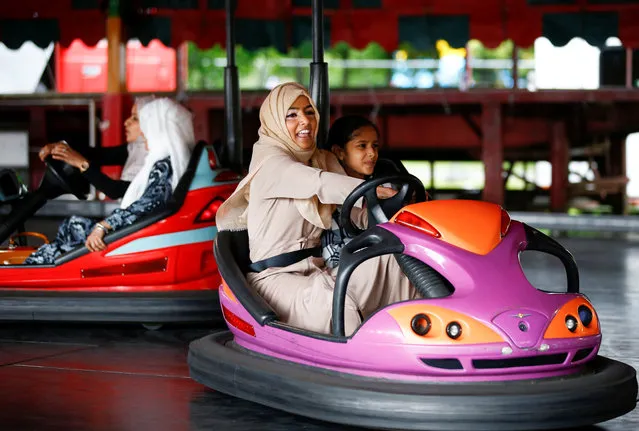 People enjoy fairground attractions following Eid al-Fitr prayers, in Small Heath Park in Birmingham, Britain, June 15, 2018. (Photo by Henry Nicholls/Reuters)