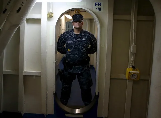 A crew member stands guard in a doorway as U.S. Defense Secretary Ash Carter tours the USS Eisenhower off the coast of Virginia, in the Atlantic Ocean, December 10, 2015. Carter visited the carrier with Indian Defence Minister Manohar Parrikar to demonstrate U.S. Navy aircraft carrier flight operations. (Photo by Mark Wilson/Reuters)