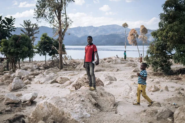 A survivor poses for a photograph where his house was swept away by a landslide in early May in the village of Bushushu on the shores of Lake Kivu in Kalehe Territory, South Kivu Province, eastern Democratic Republic of Congo on June 9, 2023. On May 4, 2023, landslides buried part of the villages of Bushushu and Nyamukubi. One month after the disaster, nearly 450 people were buried and more than 2,500 still remain unaccounted for. (Photo by Alexis Huguet/AFP Photo)