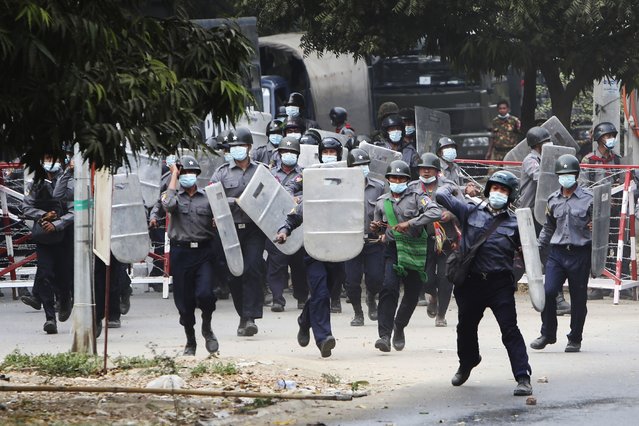 Police  charge forward to disperse protesters in Mandalay, Myanmar on Saturday, February 20, 2021. (Photo by AP Photo/Stringer)