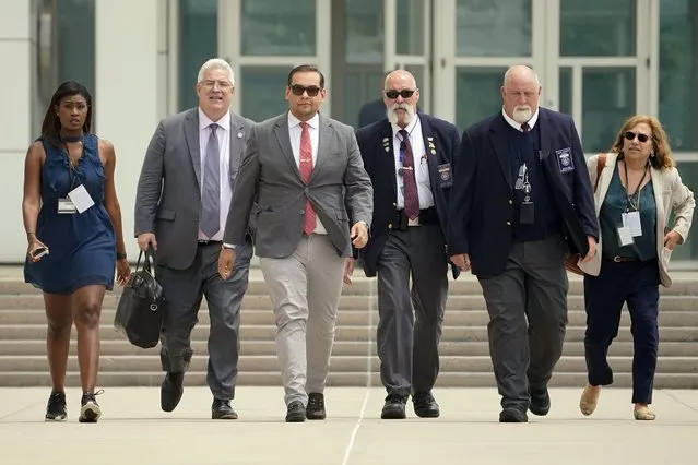 U.S. Rep. George Santos, third from left, with his attorney Joseph Murray, second from left, depart federal court with security and journalists in tow, Friday, June 30, 2023, in Central Islip, N.Y. Santos returned to court Friday for the first time since pleading not guilty last month to charges that he duped donors, stole from his campaign, collected fraudulent unemployment benefits and lied to Congress about being a millionaire. (Photo by John Minchillo/AP Photo)