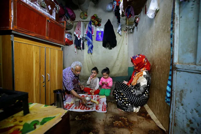 Ahmad Farea and his family sit for a meal at their house in Sanaa, Yemen on February 25, 2021. (Photo by Nusaibah Almuaalemi/Reuters)