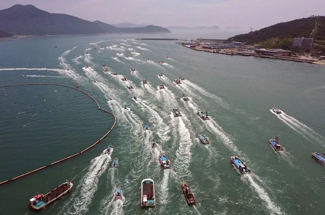 South Korean fishing boats stage a maritime parade to protest against the planned release of treated radioactive water from the wrecked Fukushima nuclear power plant into the sea, on the seas off Wando, South Korea, Friday, June 23, 2023. (Photo by Jo Nam-soo/Yonhap via AP Photo)