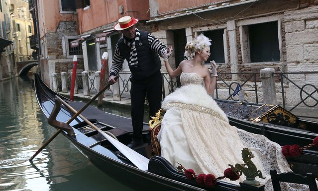 A reveller poses on a gondola in a Venice canal near St. Mark's square February 7, 2015. The Venetian carnival started on January 31 and runs until February 17, forty days before Easter celebrations. (Photo by Stefano Rellandini/Reuters)