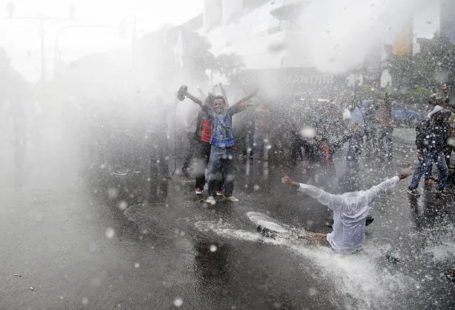 West Papuan protesters react as they police water cannon trucks spray them with water during a rally calling for the remote region's independence, in Jakarta, Indonesia, Thursday, December 1, 2016. (Photo by Dita Alangkara/AP Photo)