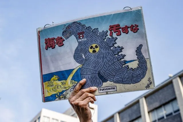A man holds a placard during a demonstration outside of the Prime Minister's official residence on April 12, 2021 in Tokyo, Japan. The Japanese government is set to announce on April 13 its decision on the disposal of treated radiation-contaminated water accumulated at the property of Fukushima Daiichi Nuclear Power Plant complex. (Photo by Takashi Aoyama/Getty Images)