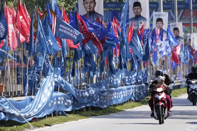 Motorcyclists pass by campaign flags ahead of the state election in Gombak, on the outskirts of Kuala Lumpur, Malaysia Wednesday, August 9, 2023. Six of Malaysia’s 13 states are holding elections now because the local governments refused to call for early polls at the same time as general elections in November. They cited the need to prepare for floods during the year-end annual monsoon season. (Photo by Vincent Thian/AP Photo)