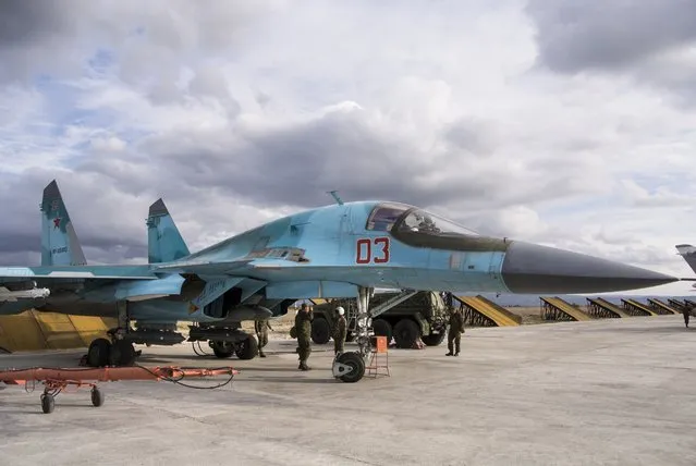 A Russian air force technician reports to a pilot that a bomber is ready for a combat mission at Hemeimeem air base in Syria Wednesday January 20, 2016. (Photo by Vladimir Isachenkov/AP Photo)