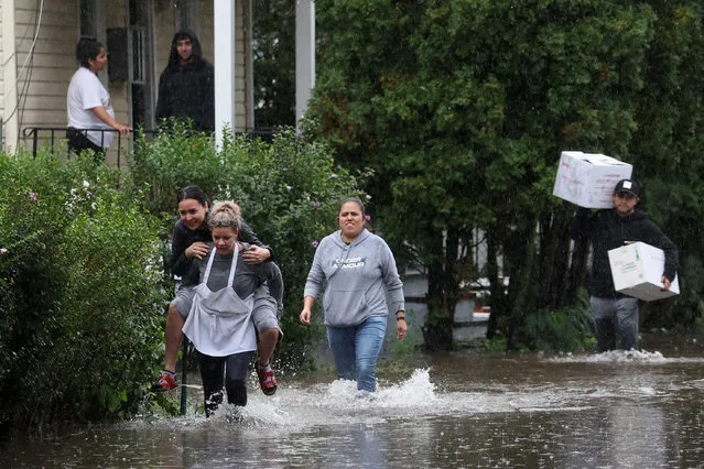 Residents walk through floodwaters during a heavy rain storm in the New York City suburb of Mamaroneck in Westchester County, New York, U.S., September 29, 2023. (Photo by Mike Segar/Reuters)