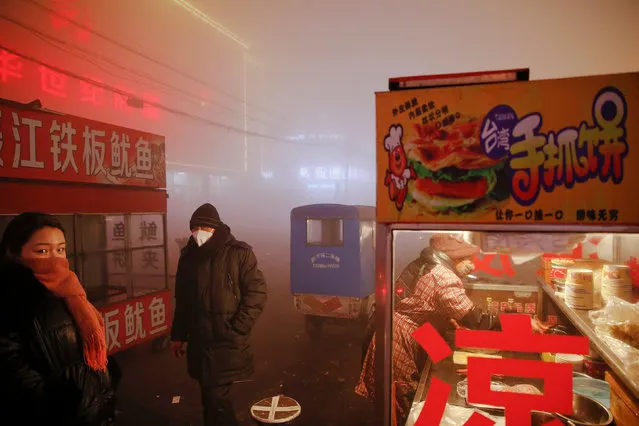 People wait for street food as heavy smog blankets Shengfang, in Hebei province, on an extremely polluted day with red alert issued, China December 19, 2016. (Photo by Damir Sagolj/Reuters)